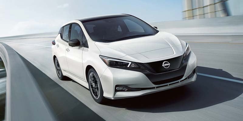 2024 White Nissan Leaf driving on road